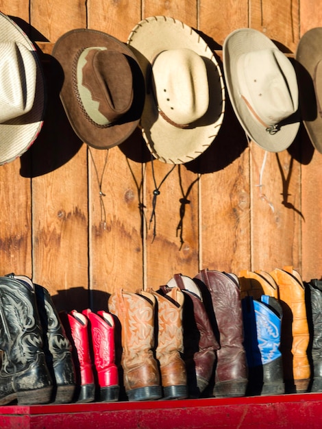 Foto cowboyhoeden en -schoenen te koop op de plank