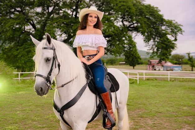 フィールドで彼女の美しい白い馬の横にある騎乗位