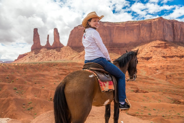 Cowgirl riding horse in Monument Valley Navajo Tribal Park in USA