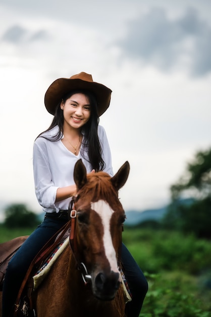 Cowgirl едет на горе с желтым небом; Концепция дружелюбного и летнего отдыха