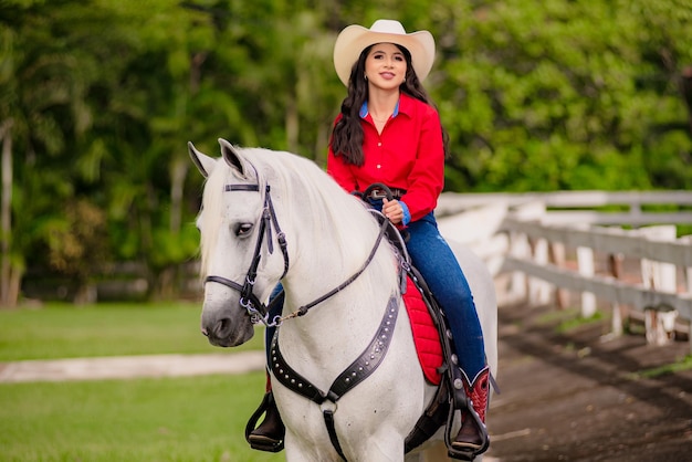 cowgirl riding a white horse walking in the field