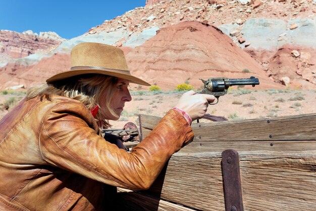 Photo cowgirl with a gun in the hand, ready to shoot