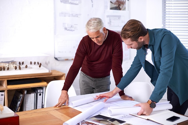 coworker men and blueprint with design at office with pencil for drawing a building renovation construction and project as architects business people and teamwork on task draft and layout