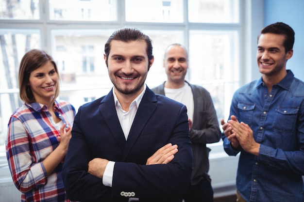 Coworkers clapping on businessman