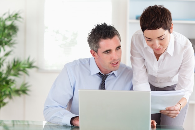 Coworkers comparing a blueprint document to an electronic one