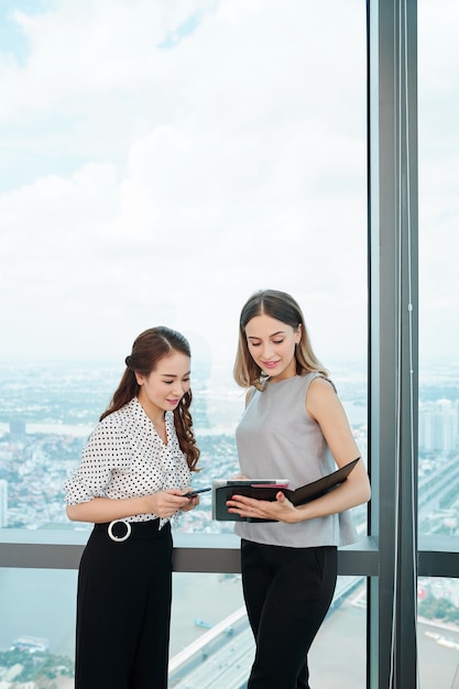 Coworkers discussing report on digital tablet