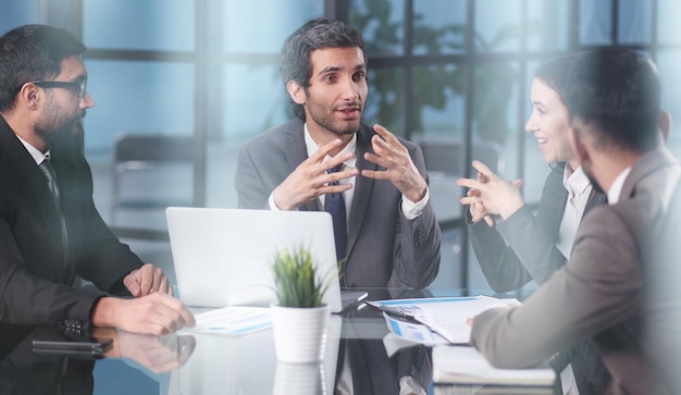 Coworkers gather in boardroom discuss ideas in group at briefing