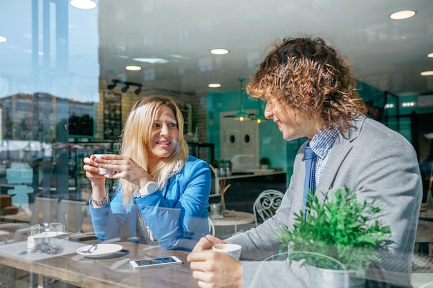 Coworkers talking on coffee break in cafeteria