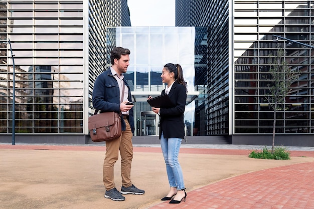 Coworkers talking in front of an office building