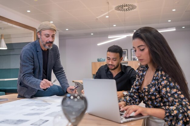 Coworkers using laptop while working together in a new project