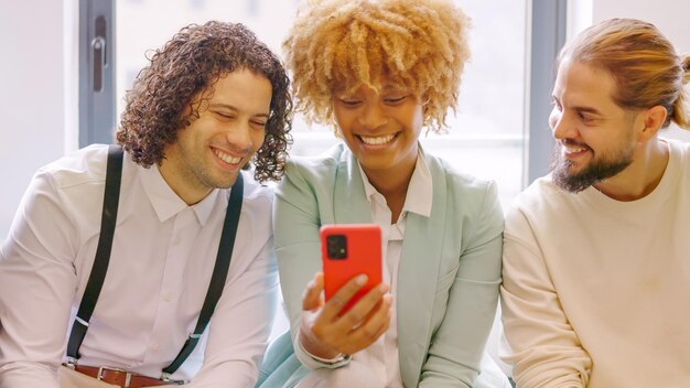 Coworkers using phone sitting relaxed during a break