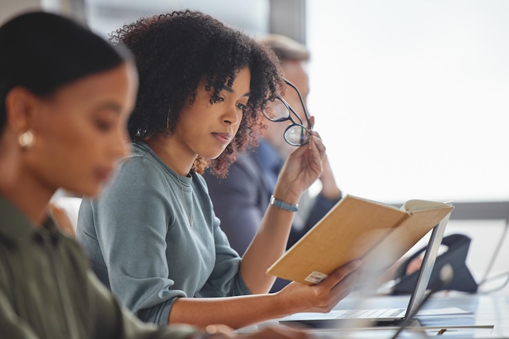 Foto coworking kantoor en werknemer lezen aantekeningen in callcenter voor virtuele technische ondersteuning of feedback vrouw leren en schrijven strategie voor klantenservice rapport en herinnering in notebook
