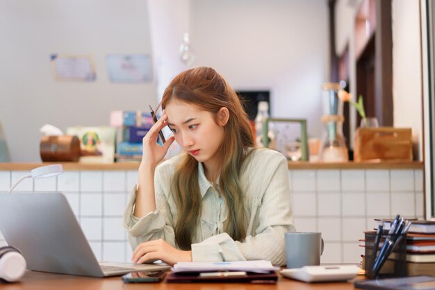 コワーキング スペース オフィス コンセプト ノート パソコンでビジネス データを読みながらストレスの多い女性起業家