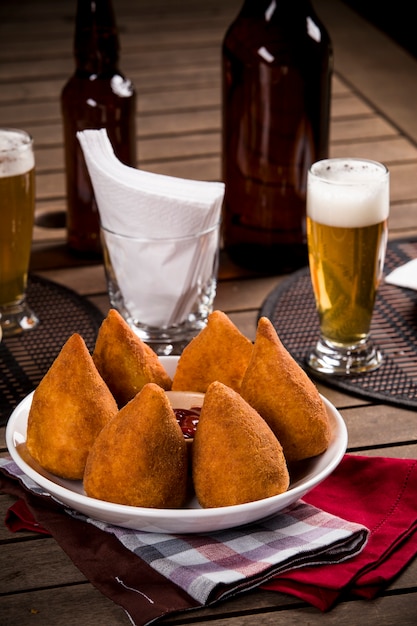 Coxinha, a Brazilian snack, with a bar in the background.