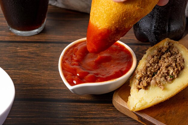 coxinha, fried brazilian snack, dipping on ketchup