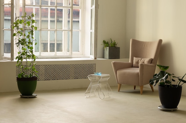 Photo cozy apartment interior with huge window armchair with small acrylic table and plants