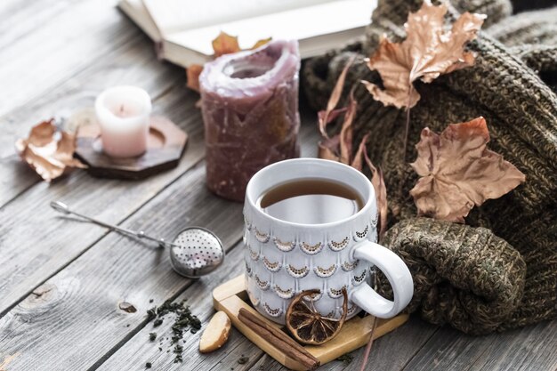 ベッドの静物シーンで居心地の良い秋の朝の朝食。ホットコーヒーの蒸しカップ、窓の近くに立っているお茶。秋。