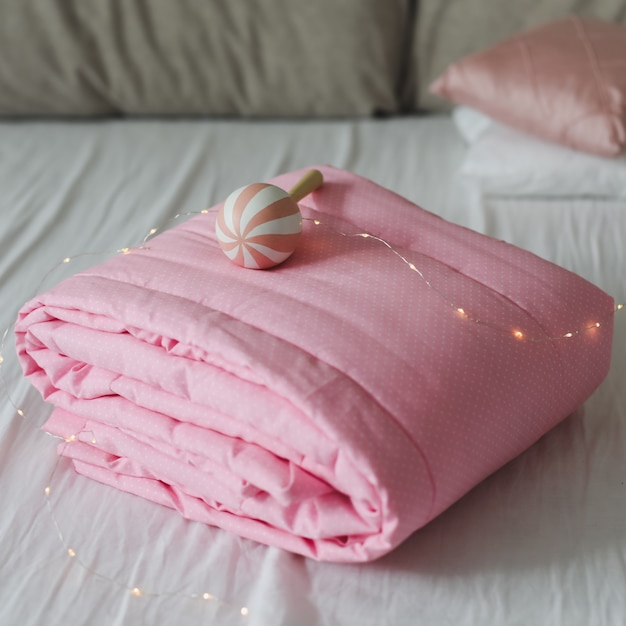 분홍색 패치 워크 담요가있는 아늑한 아기 침대. 아기 침구. 보육 용 침구 및 섬유. 낮잠과 수면 시간.