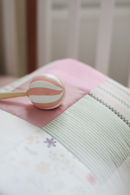 Cozy baby cot with pink patchwork blanket