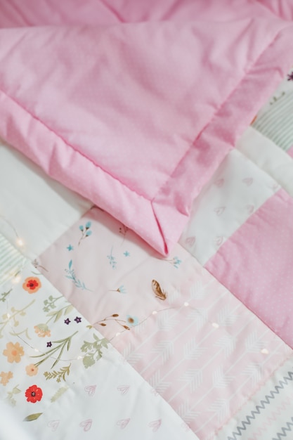 cozy baby cot with pink patchwork blanket