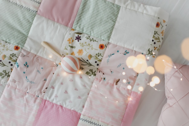 cozy baby cot with pink patchwork blanket