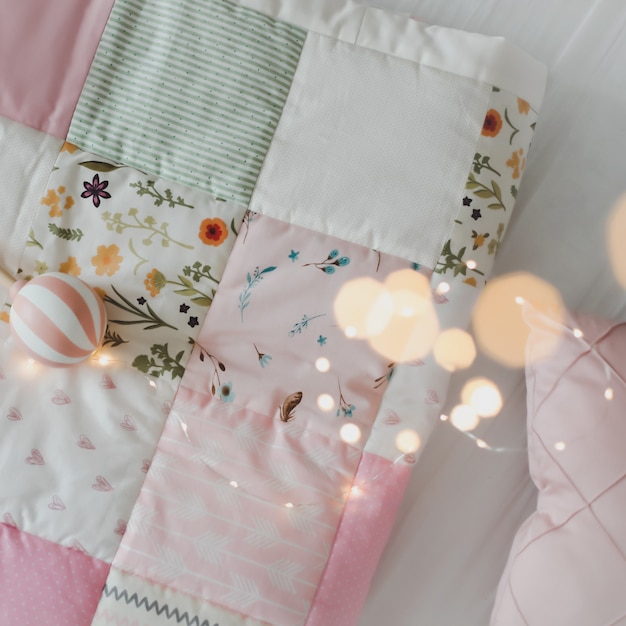 cozy baby cot with pink patchwork blanket