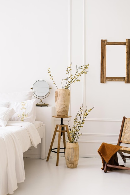 Photo a cozy bed and vases with spring branches natural bedroom decor