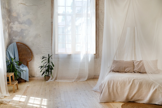 A cozy bedroom in pastel colors with a wooden floor, a large four-poster bed