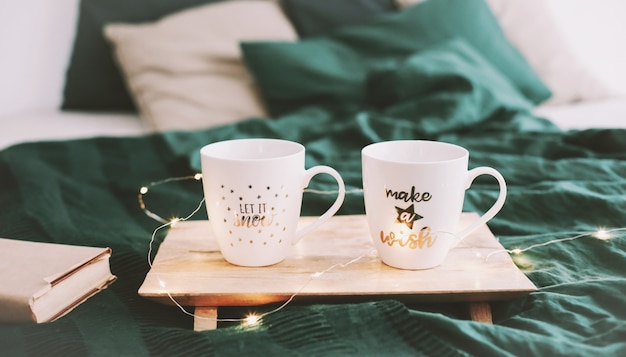 Cozy bedroom with coffee mugs in bed