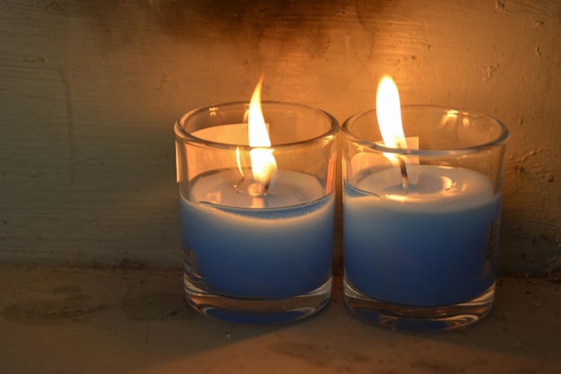 Cozy blue burning candle in 2 clear glass jar