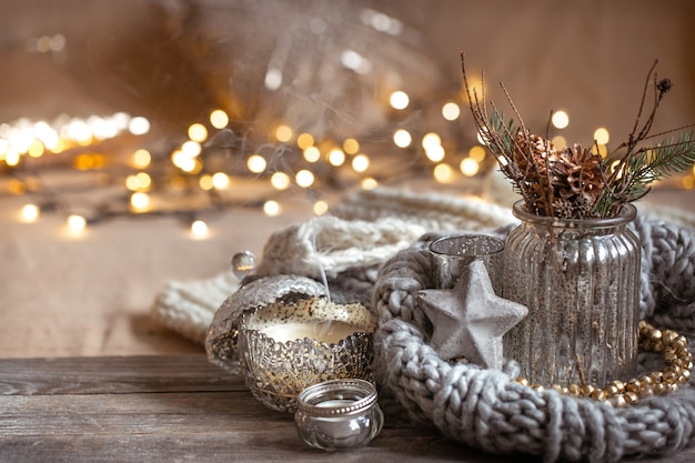 Foto accogliente composizione natalizia con candele in un candeliere decorativo. il concetto di comfort e calore domestico.