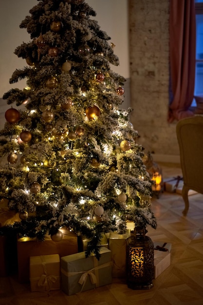 クリスマスライトとプレゼントの箱が付いた居心地の良いクリスマスツリー暖かい色親密な夕暮れ