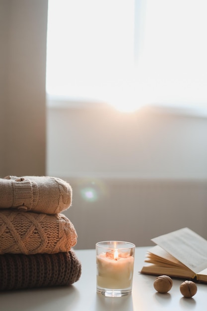 Cozy comfortable hygge home atmosphere and still life with a cup candle book and sweaters