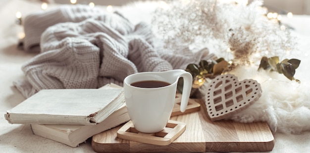 Cozy composition with a cup of coffee on a saucer and home decor details.