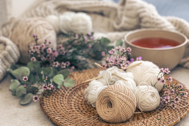 Cozy composition with knitting threads a cup of tea and flowers