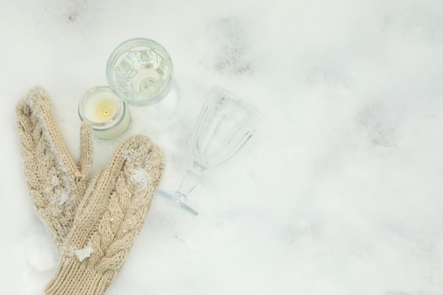 Cozy concept with glasses, candle and mittens  outdoor in winter