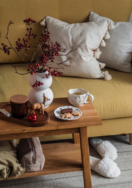 Уютный уголок гостиной желтый диван с декоративными подушками деревянная скамейка с чашкой зеленого чая и десертом