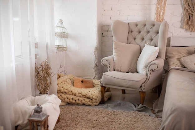 Cozy decorated living room for Christmas with comfortable grey armchair and pillows