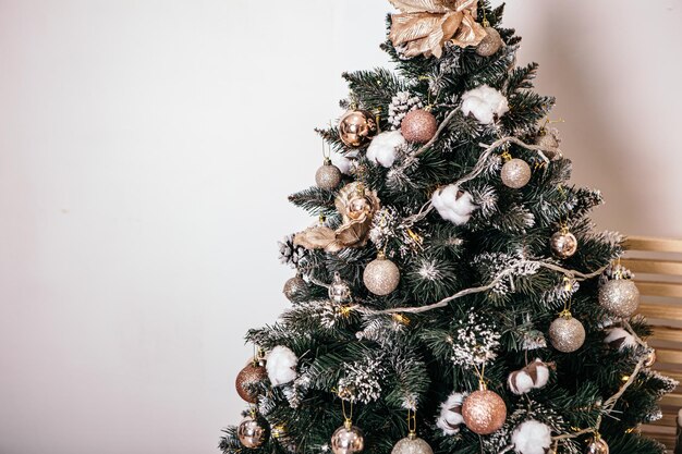 緑のクリスマスツリーの贈り物がカーペットの花輪にプレゼントする居心地の良いフラットなアパートの部屋