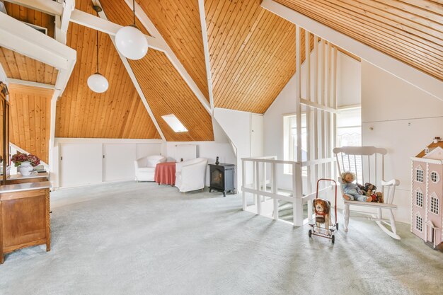 Cozy furnished attic with a high wooden ceiling and light gray carpet