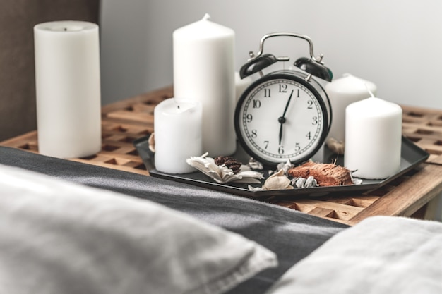 Cozy gray bedroom interior with comfortable bed near wooden night table with candle