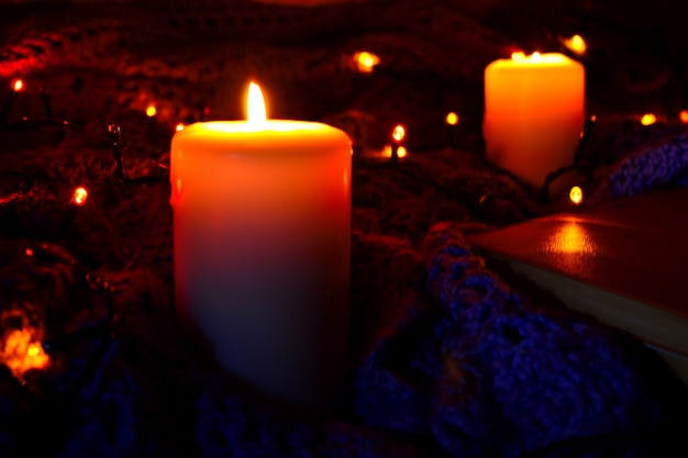 격자 무늬와 밤에 촛불 아늑한 집 배경. 불타는 초 및 크리스마스 불빛.
