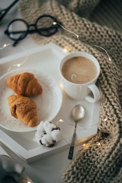 Cozy home breakfast warm blanket coffee and croissant on white