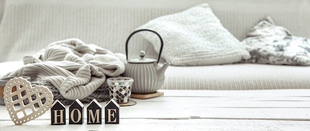 Cozy home composition with a teapot, knitted items and Scandinavian decor details. concept of home comfort and modern style.