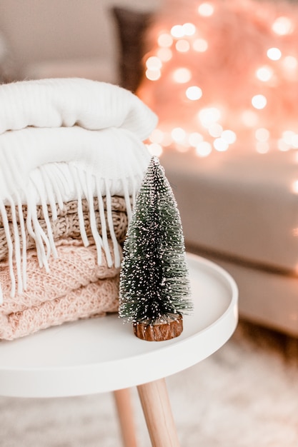 Cozy home decorations in the interior with knitting and christmas tree