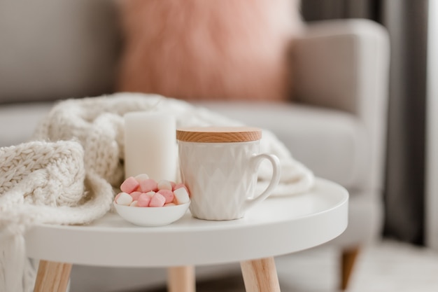 Cozy home decorations in the interior with knitting and cup of tea in the living room