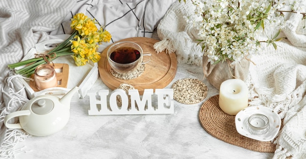 Cozy home still life with a Cup of tea and a kettle. Wooden inscription at home on the table.