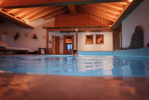 Cozy indoor swimming pool with rustic decor and lounging area tranquil ambiance