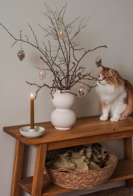 A cozy interior a burning candle an Easter bouquet a beautiful red cat on an oak bench A cozy house