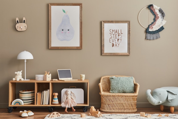 Cozy interior of child room with mint armchair, brown mock up poster frame, toys, teddy bear, plush animal, decoration and hanging cotton colorful balls